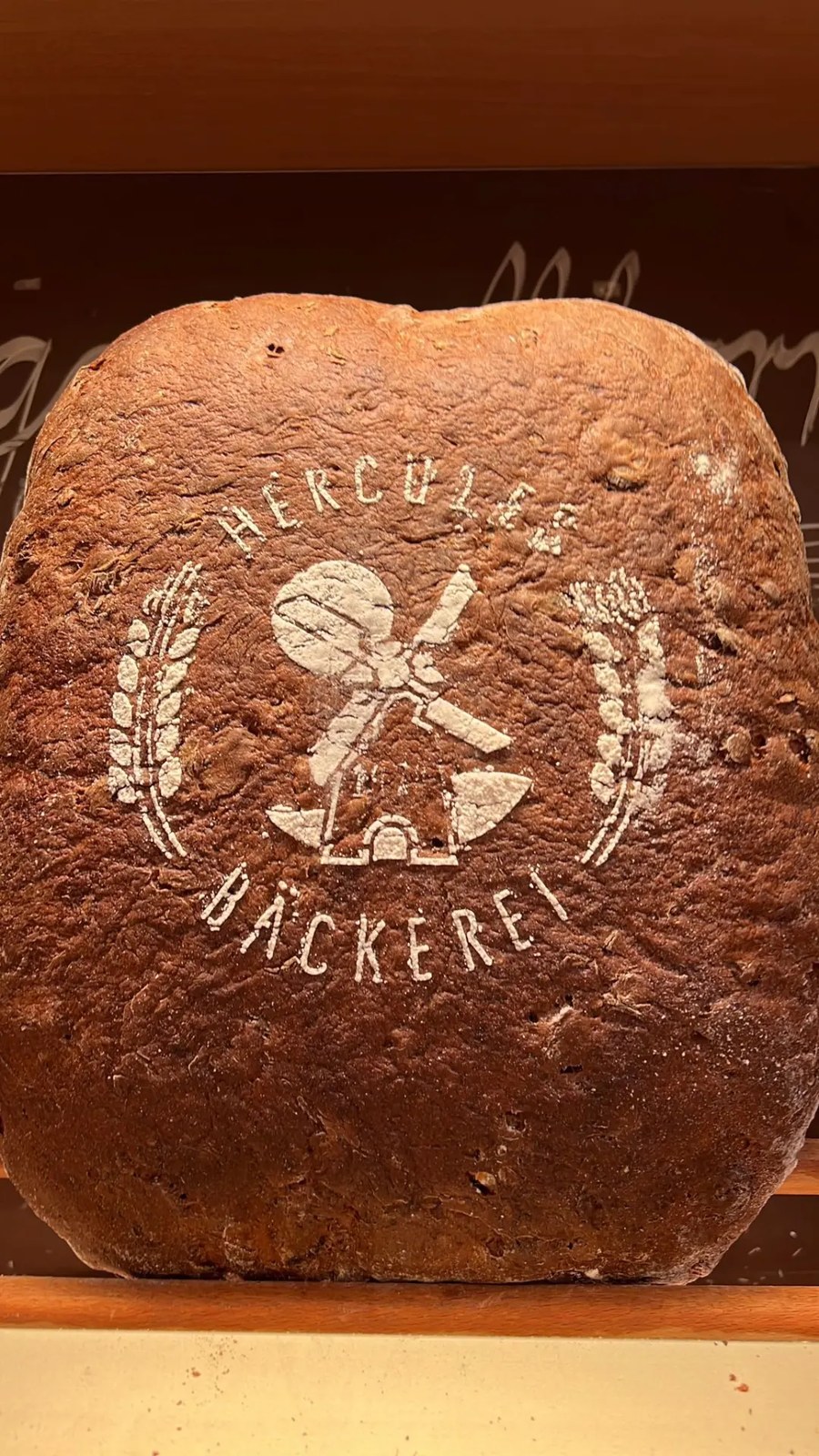 Dunkles Brot mit Hercules-Logo im Holzregal